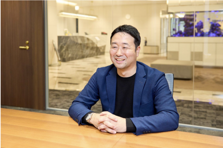 手を組み、笑顔で回答する櫻井さん